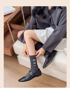 Détail de chaussettes gris foncé avec nœuds en dentelle portées avec Mary Janes