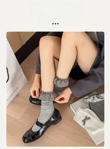 Detail of grey ribbed crew socks featuring plaid ruffle lace trim on a model