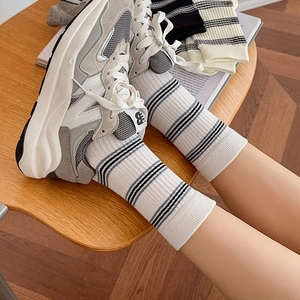 Women's autumn striped crew socks paired with casual sneakers for a stylish look