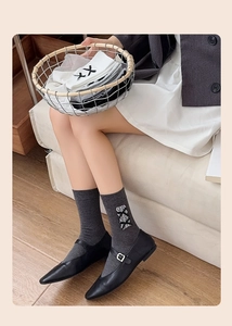 Détail de chaussettes grises et blanches en dentelle avec nœuds et broderies