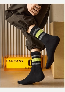 Close-up of black men's crew socks with neon green stripes in a high-fashion setting