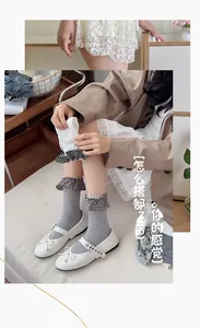 Detail of light gray crew socks featuring vertical ribbing and plaid ruffle trim lace