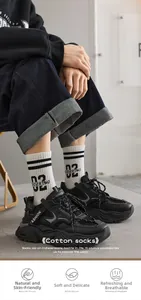 Detail of white cotton crew socks with black stripes and text paired with black sneakers