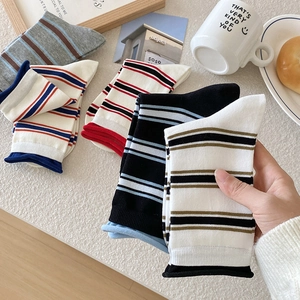 Set di calze a righe in cotone con polsini arrotolati in un ambiente domestico accogliente