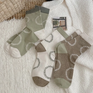 Three pairs of stylish color-block crew socks with white dotted ring patterns on faux fur