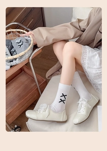 Détail de ballerines blanches avec lacets en dentelle et chaussettes montantes à nœuds