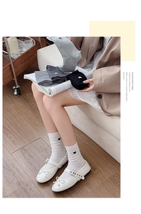 Detail of white cotton crew socks with small heart embroidery and Mary Jane shoes