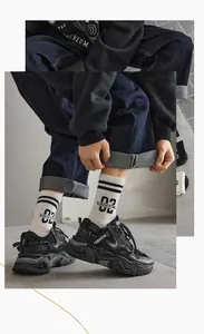 Close-up of black platform sneakers with FASHION text and lettered crew socks
