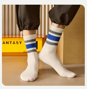 Close-up of men's white crew socks with blue and grey stripes and ribbed cuffs