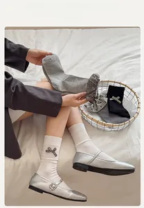 Close-up of lolita crew socks with bow embellishment and plaid lace trim details