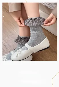 Detail of grey ribbed socks with plaid ruffle cuffs and elastic lock waist design