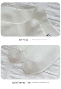 Detail view of the stereo heel and manual suture on white cotton dog pattern socks