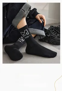 Detail of men's knit mid-calf socks with white 'M-1988' lettering and ribbed texture
