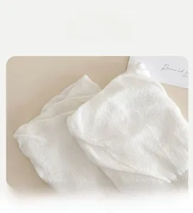 Close-up of white ballet-style socks showing the high-elastic ribbed cuffs and knit texture