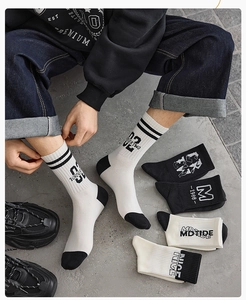 Detailed view of mid-calf athletic socks with black and white contrast lettering and ribbing