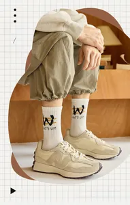 Detail of white athletic crew socks with embroidered letters and trendy stripes