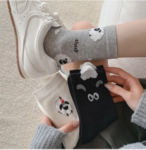 Detailed knit texture of cartoon sheep socks in gray, black and white cotton