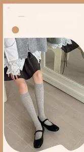 Close-up of grey ribbed calf socks paired with black Mary Jane shoes for a retro look