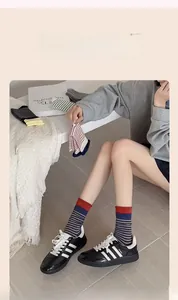 Detailed view of striped cotton crew socks in multiple colors with rolled cuff texture