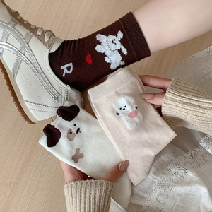 Chaussettes mignonnes avec chiens en peluche 3D et motifs lapins sur sol en bois