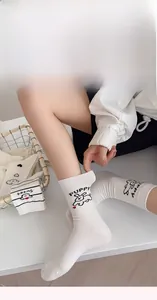Close-up of white cotton socks with black puppy pattern and PUPPY text in stylish style