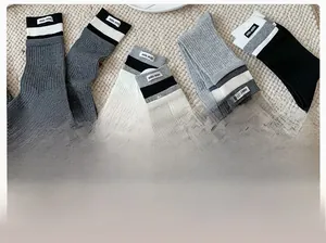 Close-up of ribbed cotton crew socks in grey and black with woven brand labels