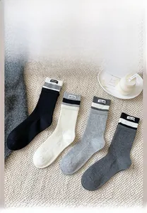 Detailed close-up of ribbed cotton crew socks in grey, beige and black with stripes