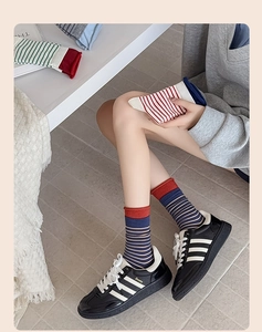 Detail view of blue and white striped cotton socks with contrast rolled cuff design