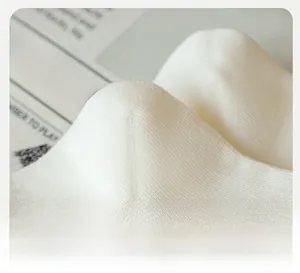 Close-up of reinforced three-dimensional heel on white cotton sports socks with ribbed texture