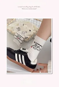 Detail of white mid-calf socks with puppy graphics and a comfortable ribbed cuff