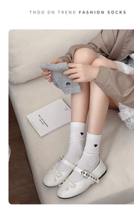 Close-up of cotton mid-tube socks with vertical ribbing and small heart embroidery