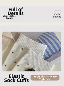 Detailed close-up of elastic ribbed cuffs and black polka dot pattern on white cotton socks