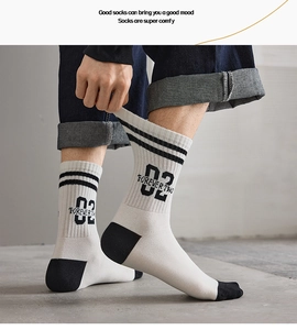 Detail showing elastic stretch of white mid-calf crew socks with black stripe and 02 lettering
