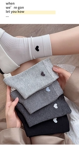 Detailed macro view of high-quality rib-knit cotton socks featuring tiny embroidered hearts