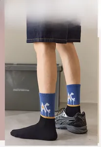 Close-up of blue crew socks with white letters and yellow stars in a tri-color design