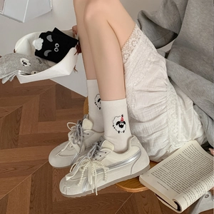 Cute cartoon sheep mid-calf socks and pearl decorated sneakers on a wooden floor
