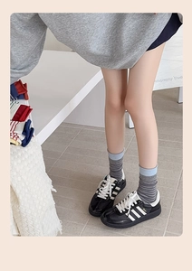 Detail view of retro striped crew socks in gray and blue with vintage collegiate style