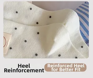 Detailed close-up of reinforced heel on white knit socks with gray polka dot pattern