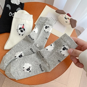 Three pairs of mid-calf socks with 3D sheep patterns in black, white, and grey colors