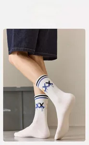 Detail of high-elasticity ribbed cuff on white athletic socks with blue stripes