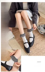 Close-up of white ribbed socks featuring plaid ruffle trim details and Mary Jane shoes