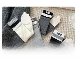 Close-up of ribbed knit socks featuring contrast stripes and branded woven labels