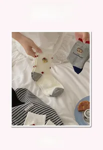 Détail de chaussettes en coton marine avec broderie chien et revers côtelés