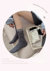 Close-up of women's polka dot socks featuring lettuce edge cuffs and M.E.K. letter labels