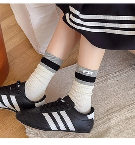 Detail of ribbed knit crew socks with grey contrast stripes and min min woven label