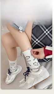 Detail showing white crew socks with cute cat patch and MEOW lettering on model