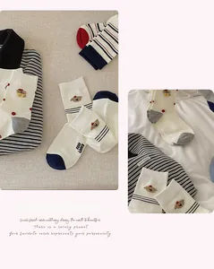 Détail de chaussettes en coton bleu marine avec broderie chiot et motifs à rayures