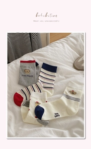 Détail de broderie chiot mignon sur chaussettes en coton à rayures gris et blanc