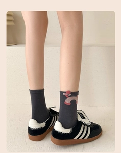 Detail view of dark grey mid-calf cotton socks with cute cartoon pattern and ribbed texture