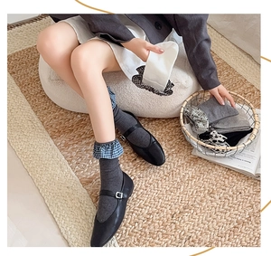 Detailed view of dark grey crew socks with blue checkered ruffle trim and cotton texture